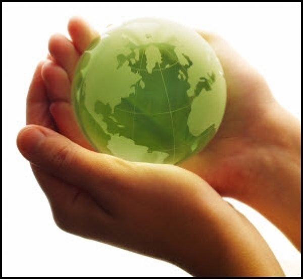 A green small globe cradled in someone's hands
